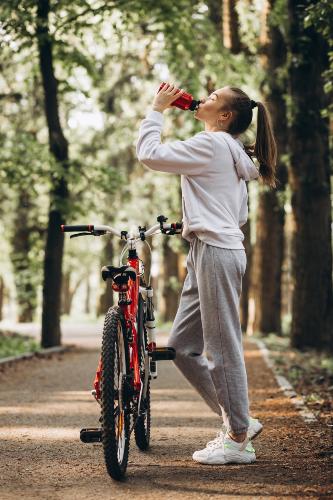 Donna che beve in bicicletta